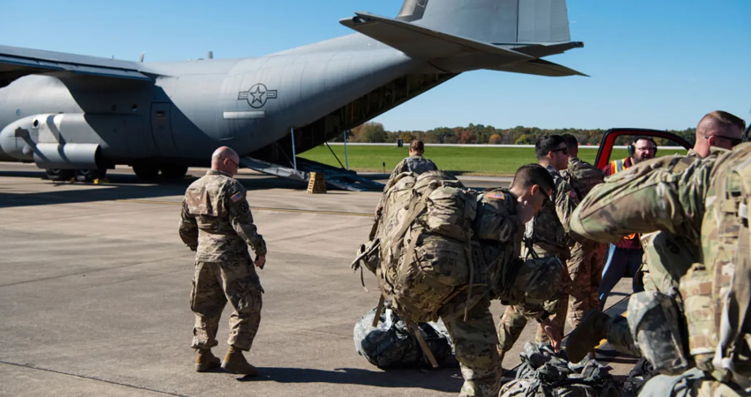 مهاجرون يسيرون بجوار ضباط شرطة من المكسيك أثناء العبور للولايات المتحدة (أ.ف.ب)