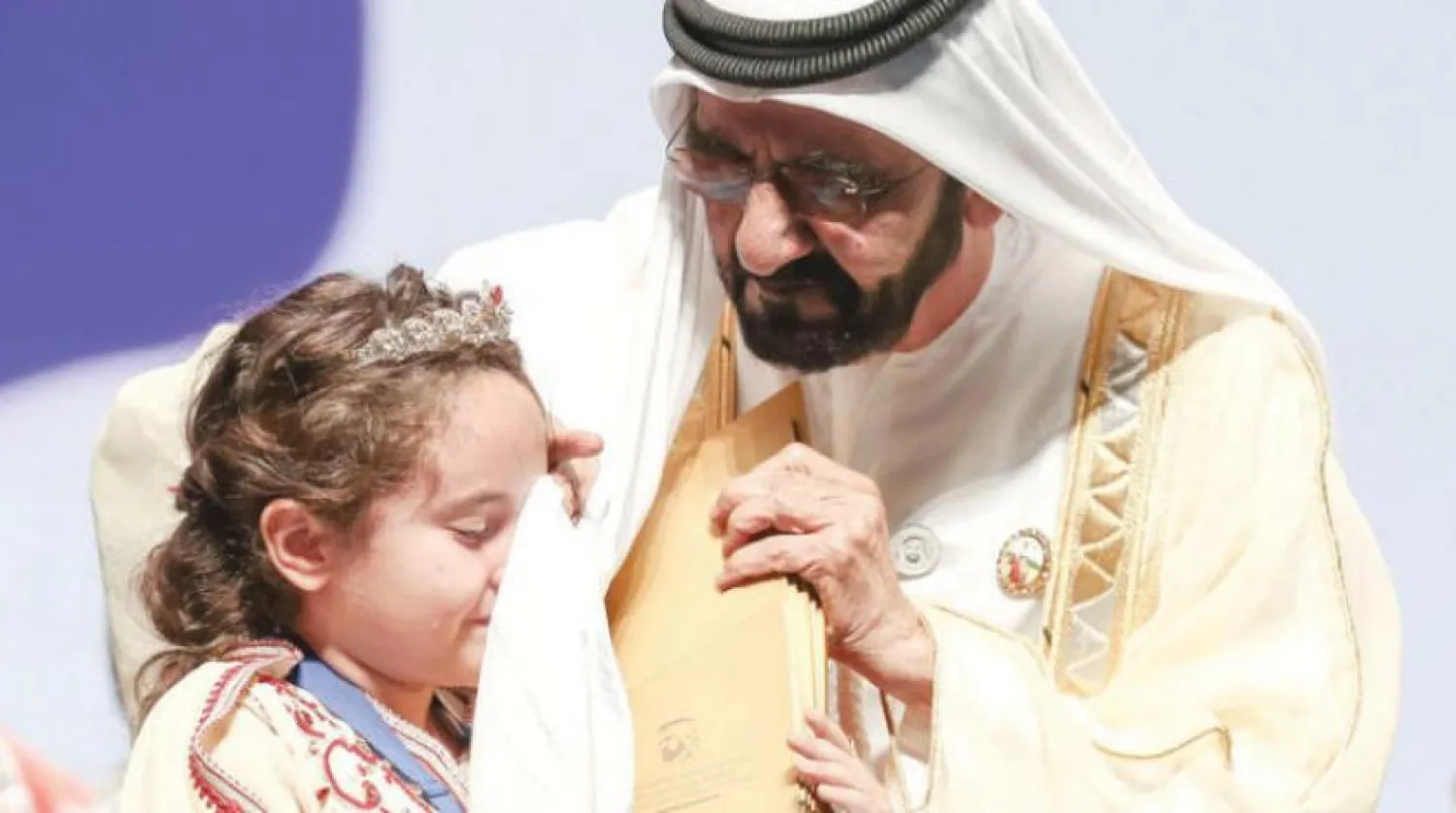 Sheikh Mohammed bin Rashid Al Maktoum wipes away the tears of Maryam Amjoun after she was crowned as Champion of the third Arab Reading Challenge. WAM