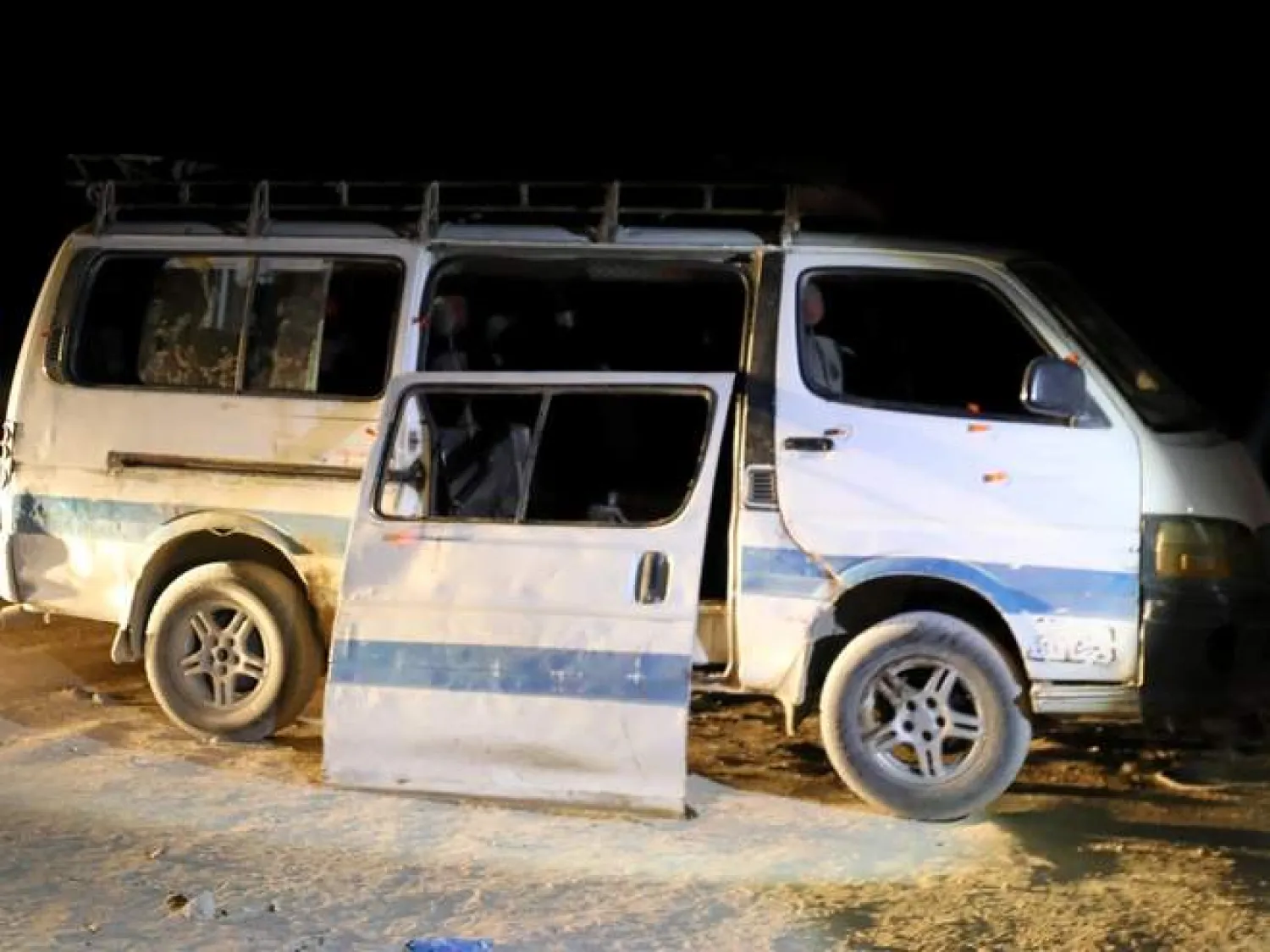 Policemen stand beside the microbus which carried Coptic Christians when gunmen opened fire (Reuters)
