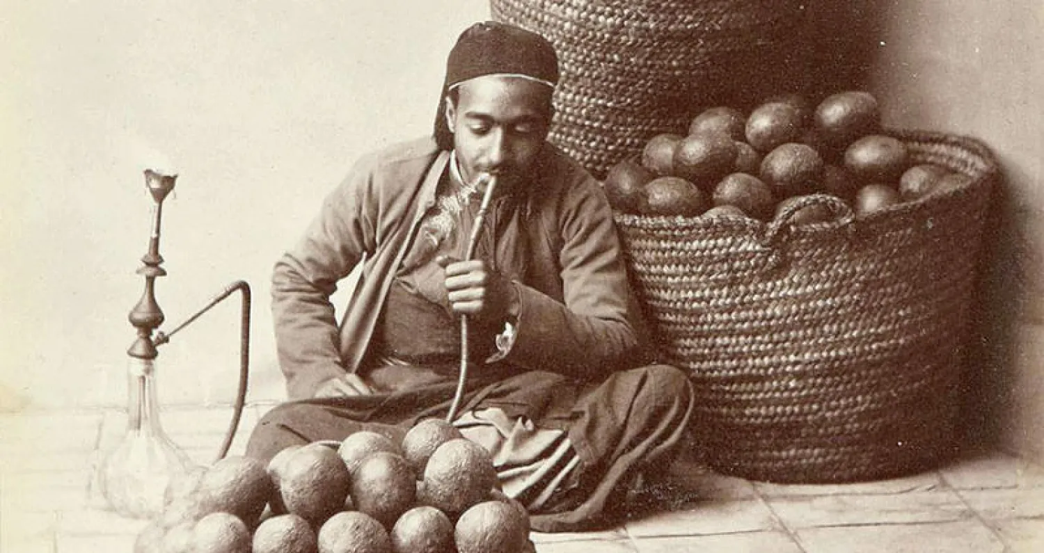 بائع الباذنجان يدخن النرجيلة وهو ينتظر الزبائن ضمن المعرض