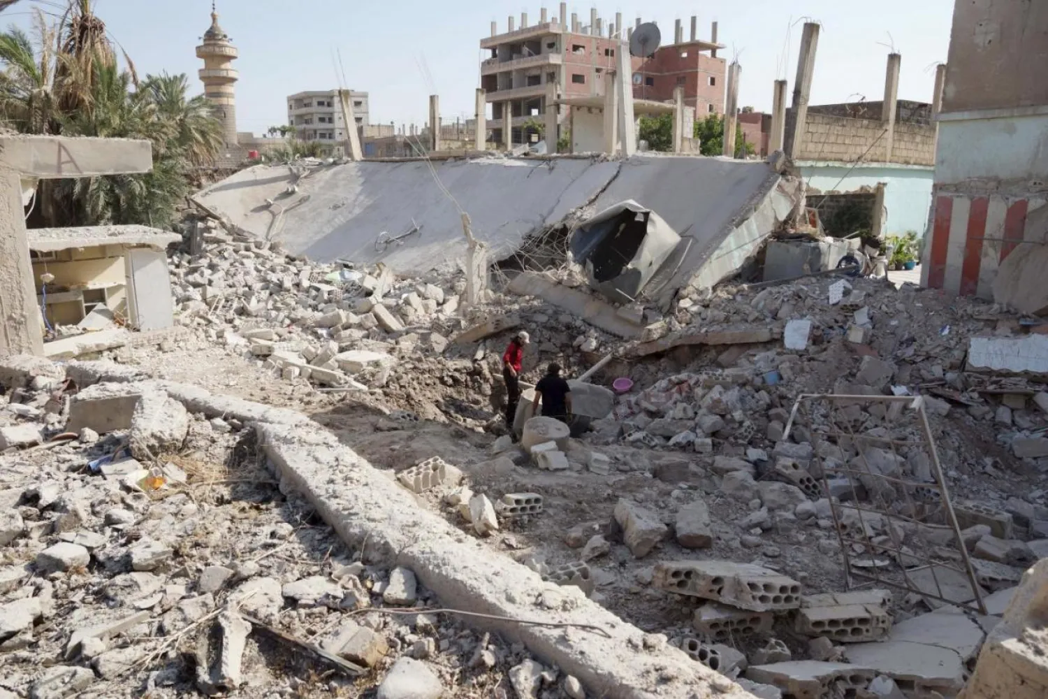 Residents inspect damage barrel bombs dropped by forces loyal to the Syrian regime in Tafas town in Daraa, Syria, July 2, 2015. REUTERS/Alaa Al-Faqir