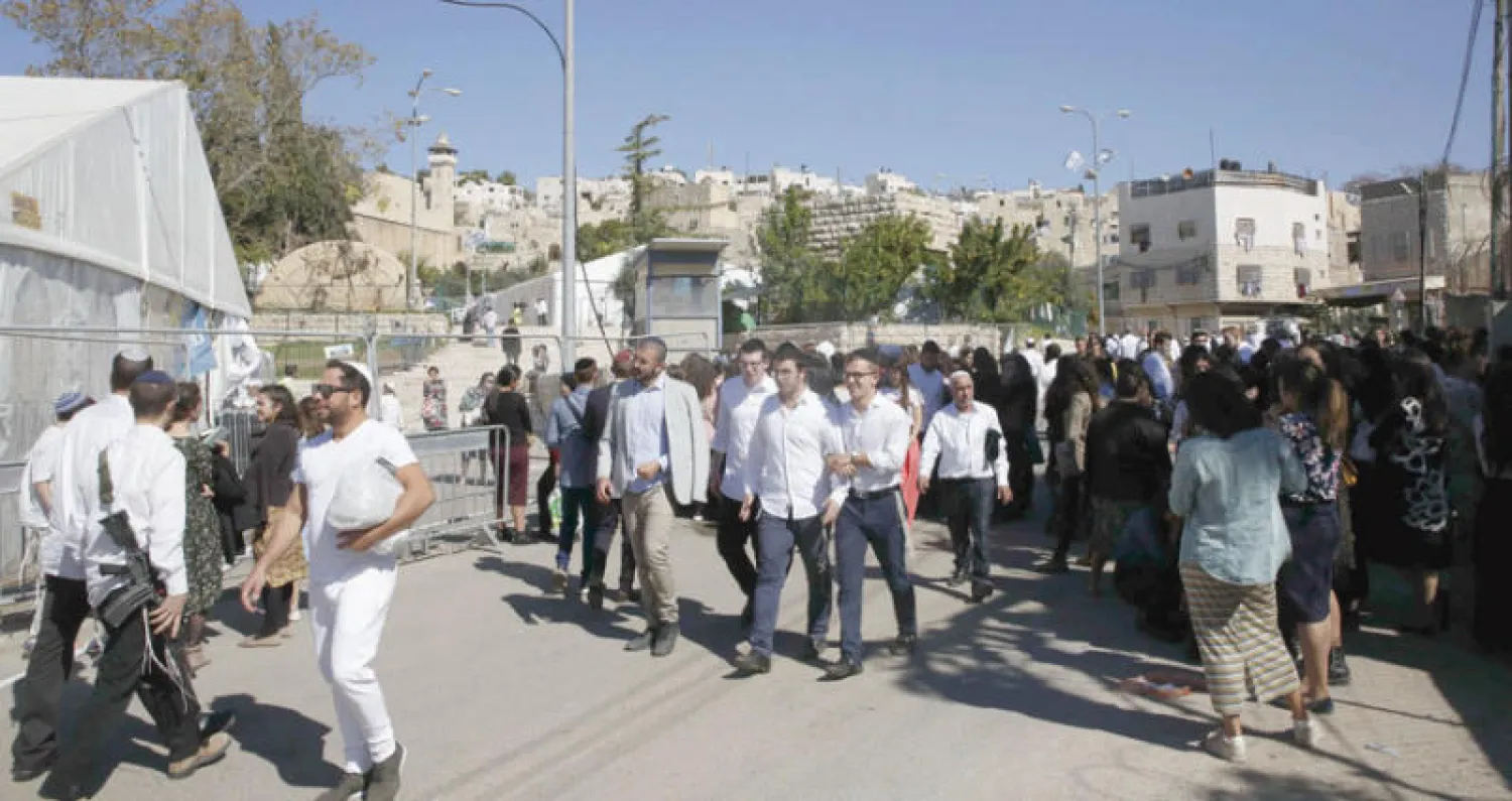 عائلات يهودية خلال احتفال ديني في مدينة الخليل (أ.ف.ب)