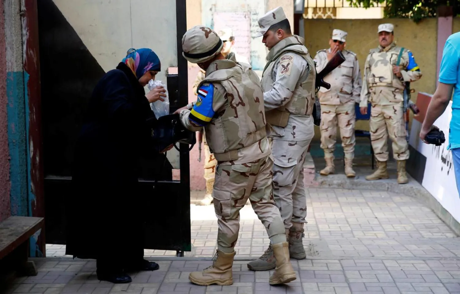 An Egyptian soldier searches a woman purse as she arrives to cast her vote during the presidential election in Cairo, Egypt, March 2018. Amr Abdallah Dalsh / Reuters