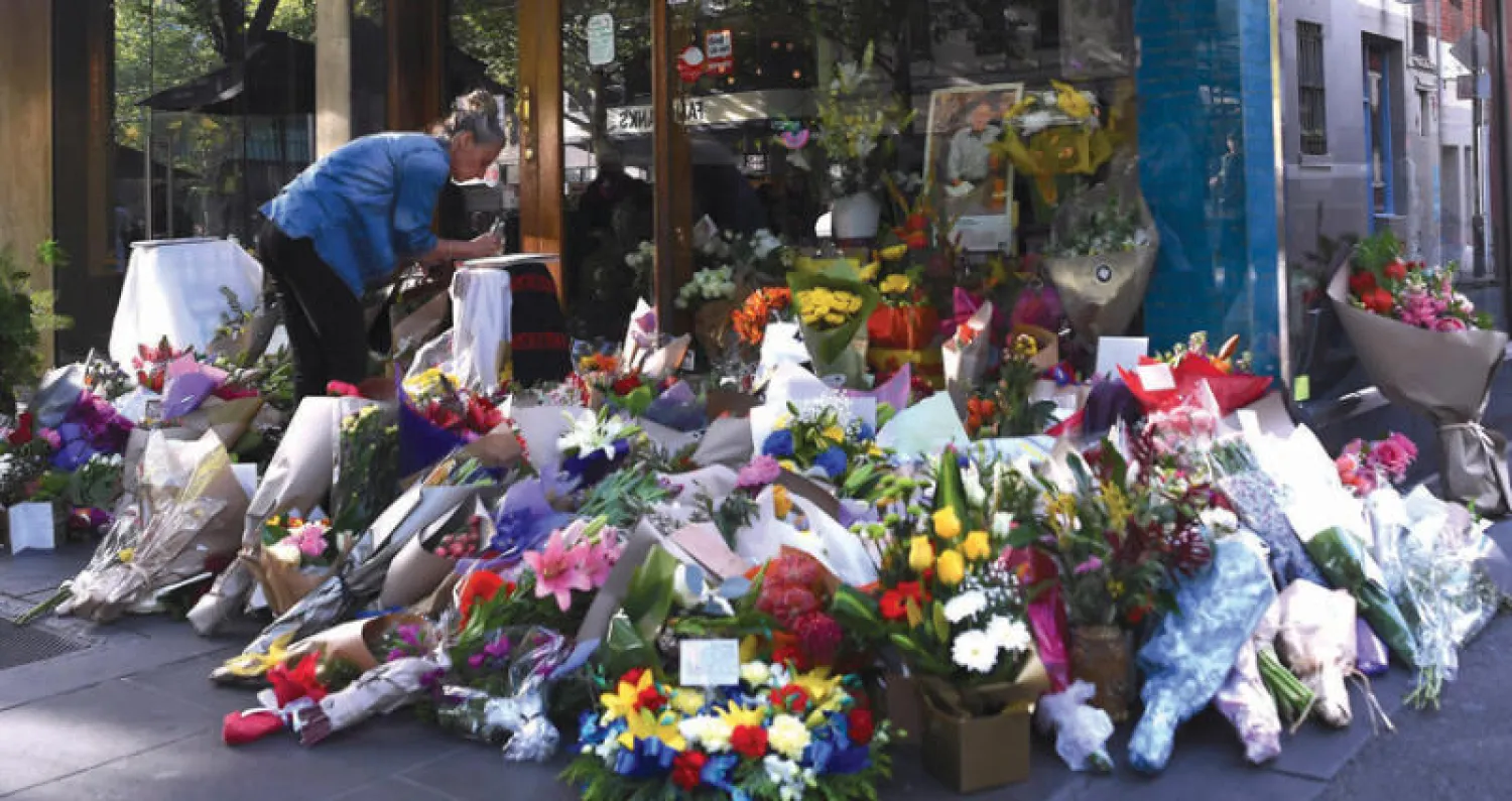 باقات من الورد أمام المقهى الذي شهد حادث الطعن في ملبورن (رويترز)