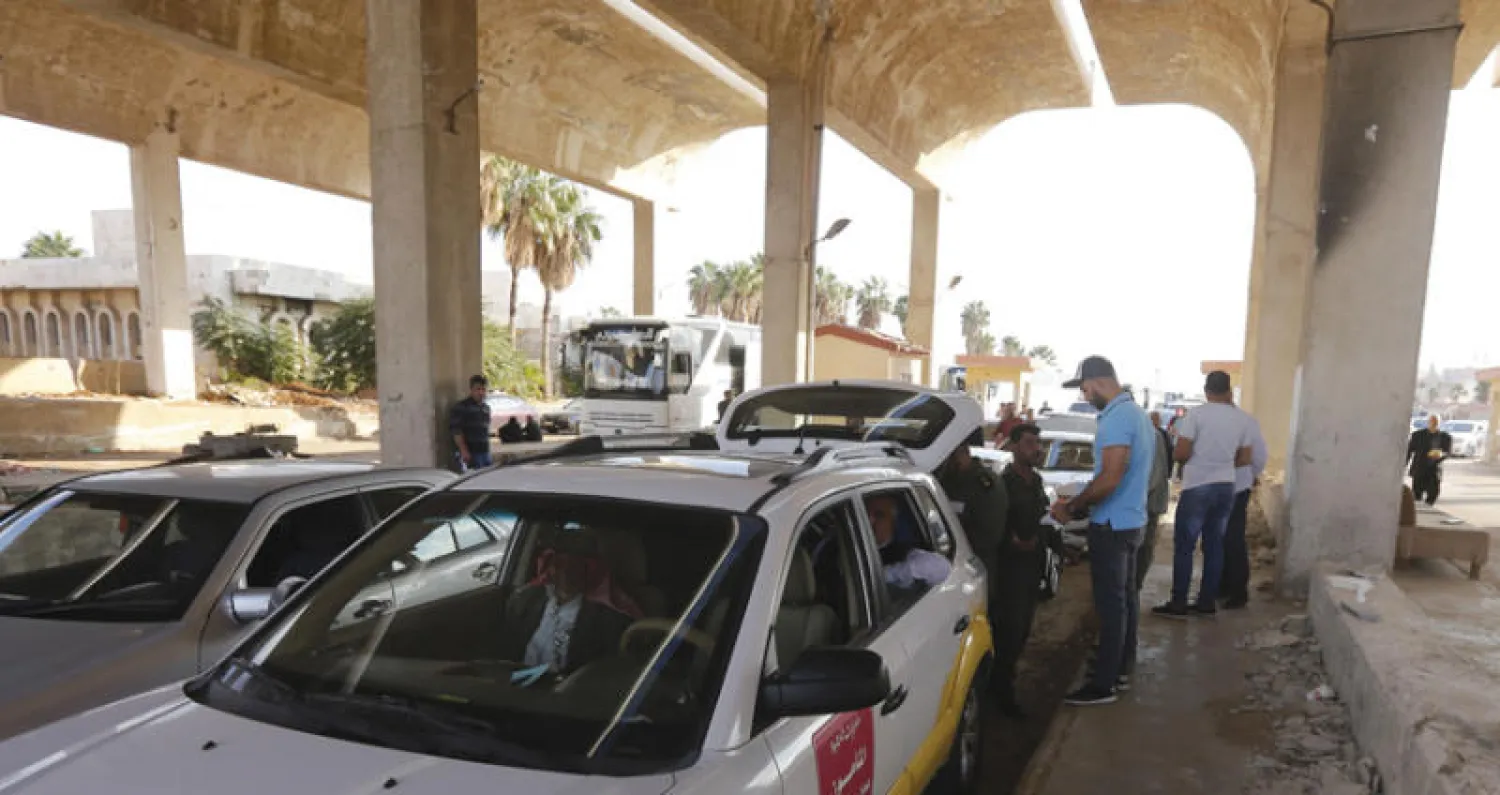 سيارات آتية من الأردن تنتظر التفتيش عند معبر نصيب على الحدود الأردنية - السورية (أ.ف.ب)