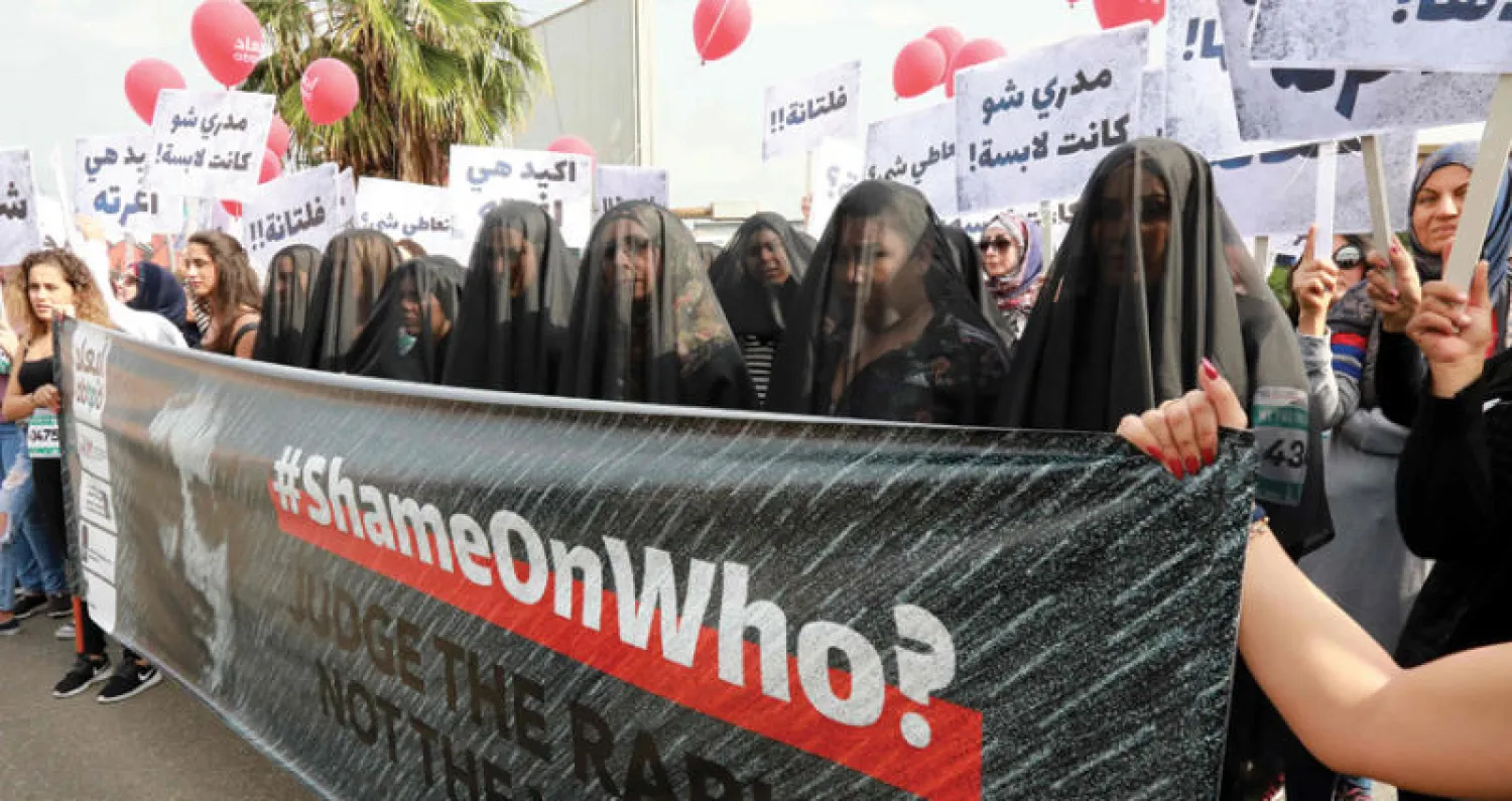 لافتة لناشطات في حقوق المرأة ضد التعديات الجنسية على النساء على هامش ماراثون لبنان الـ16 أمس (أ.ف.ب)