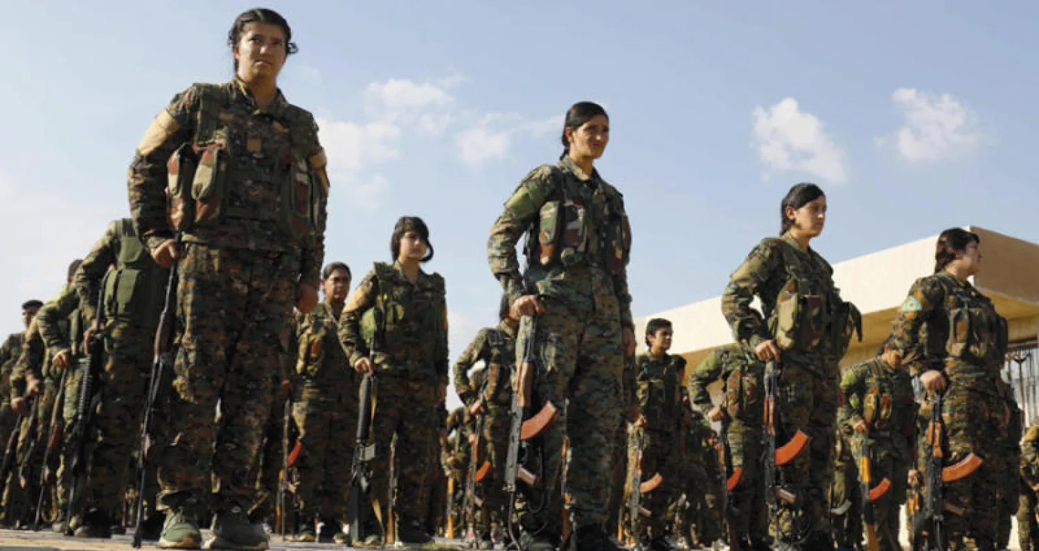 عناصر من «سوريا الديمقراطية» في استعراض عسكري أمس في القامشلي شمال سوريا أثناء جنازة أحد زملائهم (أ.ف.ب)