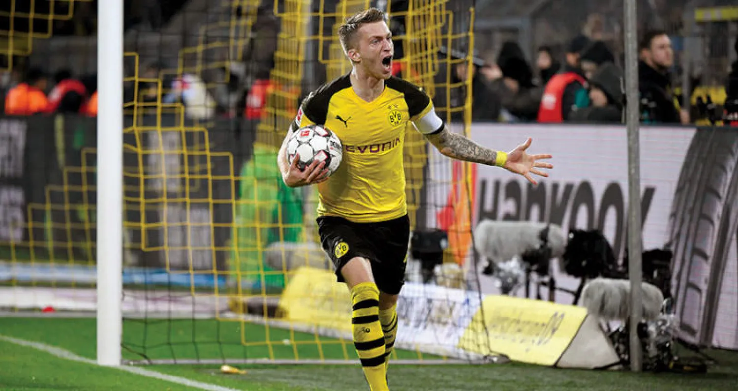 ريوس يحتفل بعد أن سجل ثنائية لدورتموند في مرمى البايرن (أ.ف.ب)