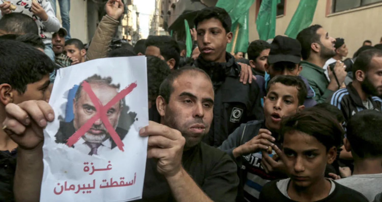 متظاهرون فلسطينيون يستعدون لحرق صورة لليبرمان أمام بيت إسماعيل هنية في غزة أمس (أ.ف.ب)