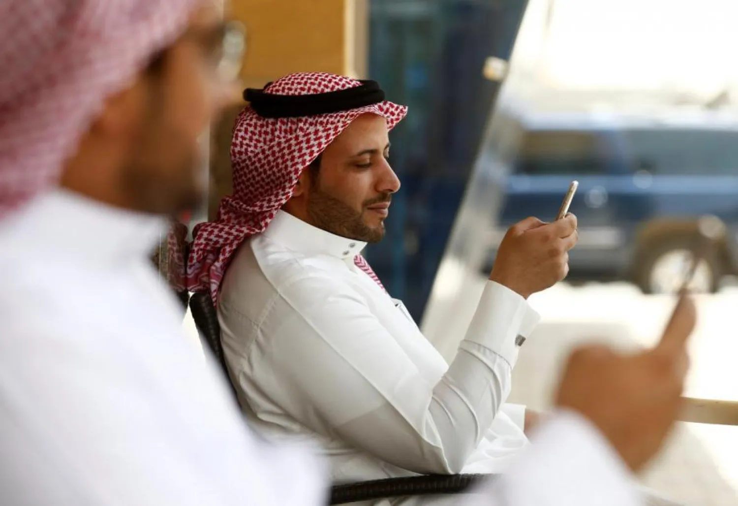 Saudi men explore social media on their mobile devices as they sit at a cafe in Riyadh, Saudi Arabia. (Reuters
