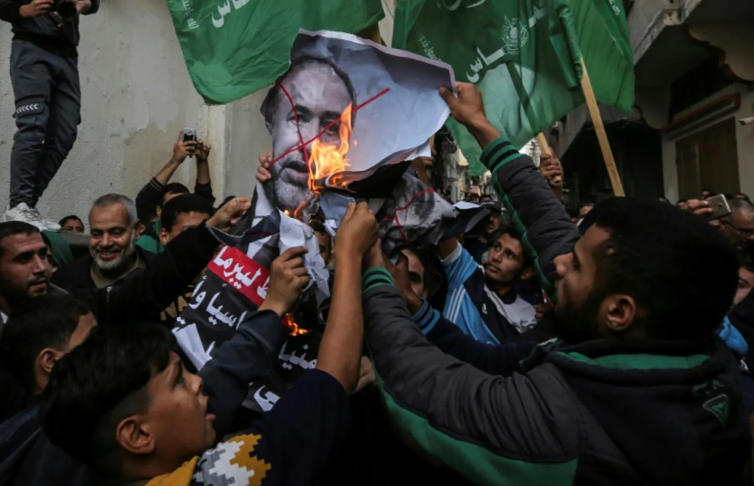 Palestinian demonstrators burn pictures of Israel's outgoing defence minister Avigdor Lieberman in Gaza on November 14, 2018 (AFP)

