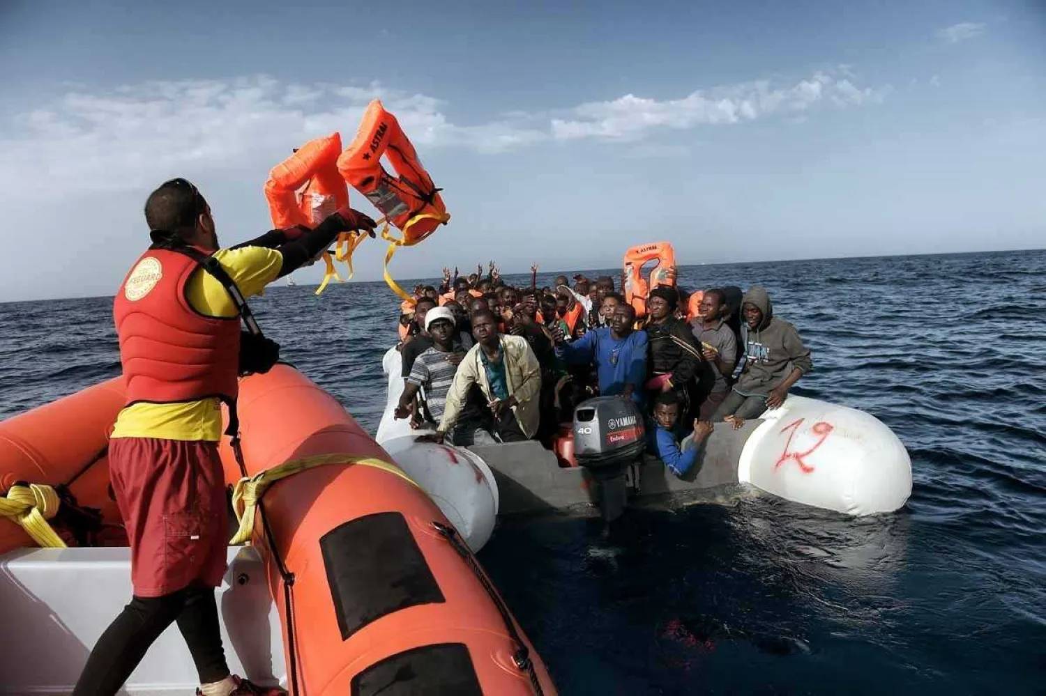 3: A member of Spanish humanitarian NGO Proactiva Open Arms,
throws life jackets to refugees and migrants during a rescue operation
off the coast of Libya on October 3, 2016.
 (AFP / Aris Messinis)
