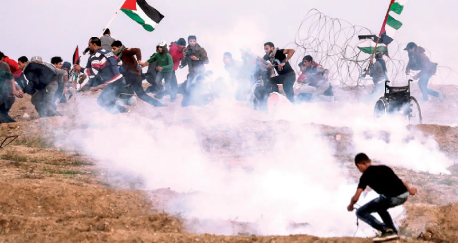 محتجون فلسطينيون خلال مواجهات مع قوات الاحتلال عند الأطراف الشرقية لغزة أمس (أ.ف.ب)