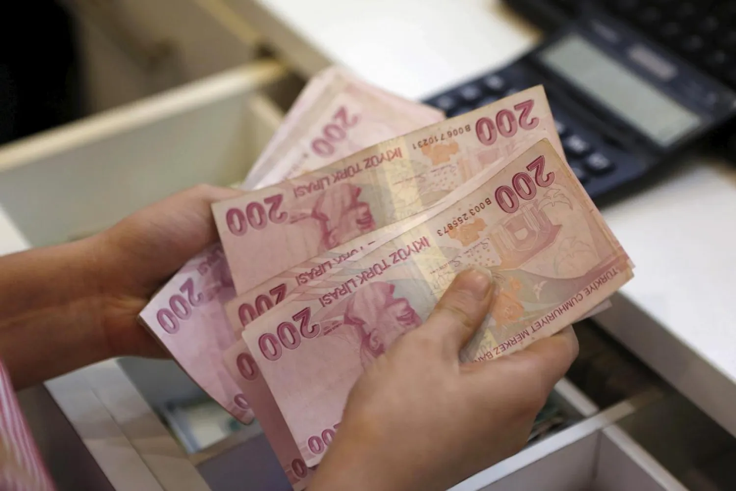 A money changer counts Turkish lira bills at an currency exchange office in central Istanbul, Turkey, August 21, 2015. REUTERS/Murad Sezer
