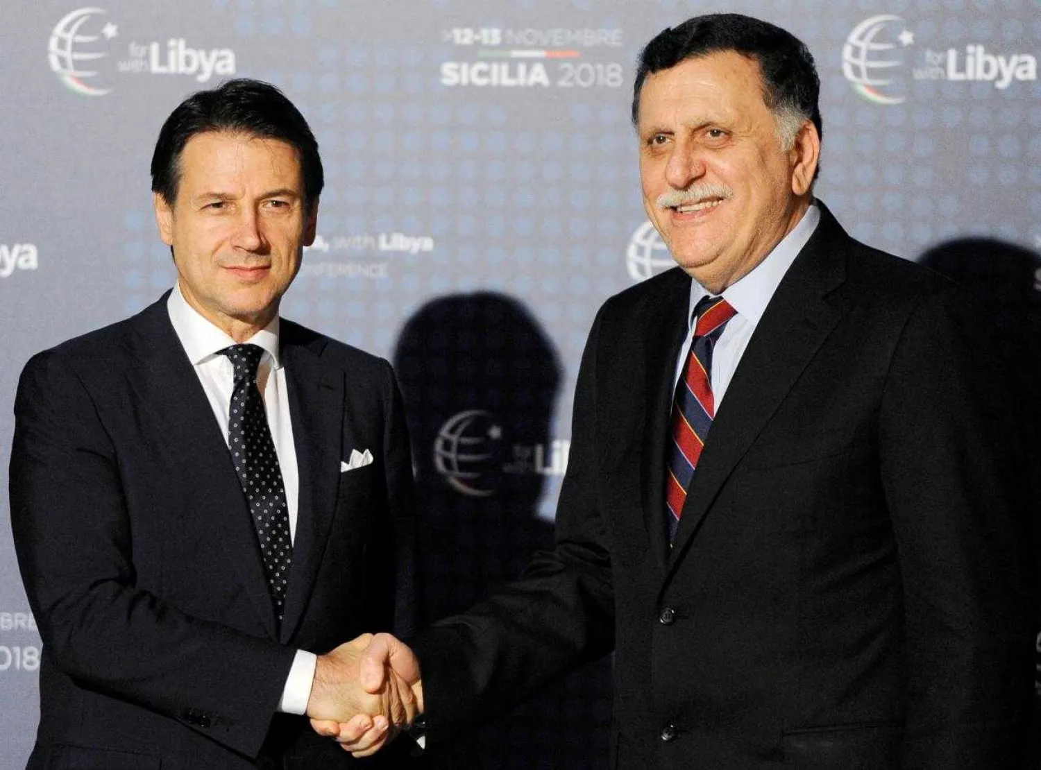 Italy's Prime Minister Giuseppe Contee welcomes Libya's Prime Minister Fayez al-Sarraj as he arrives at the venue of the international conference on Libya in Palermo, Italy, November 12, 2018. (Reuters)