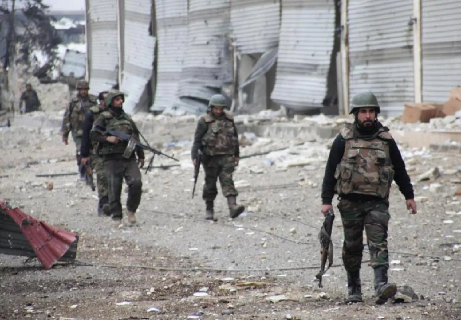 Forces loyal to head of Syria's regime Bashar al-Assad walk with their weapons in the Aleppo town of Naqaren, January 13, 2014. REUTERS/George Ourfalian