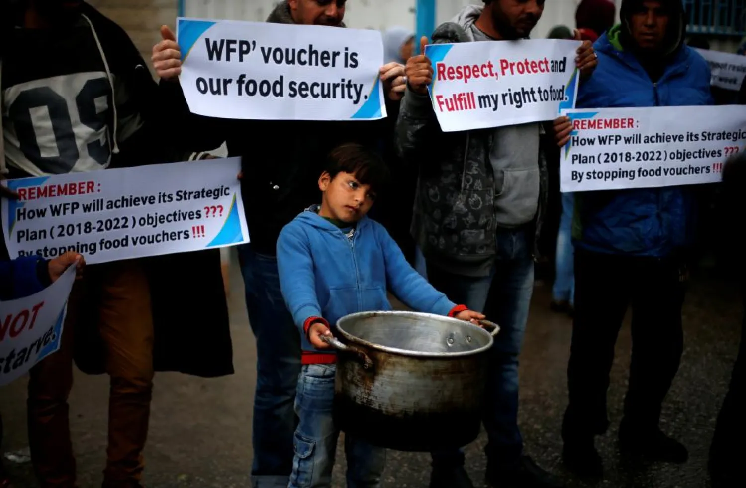 Palestinians hold signs during a protest against aid cut, outside United Nations' offices in Gaza City in January. (Reuters)