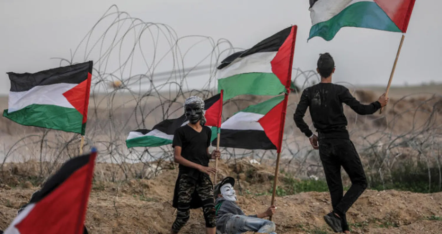 فلسطينيون يرفعون الأعلام خلال احتجاجات على حدود غزة ضد الحصار (إ.ب.أ)