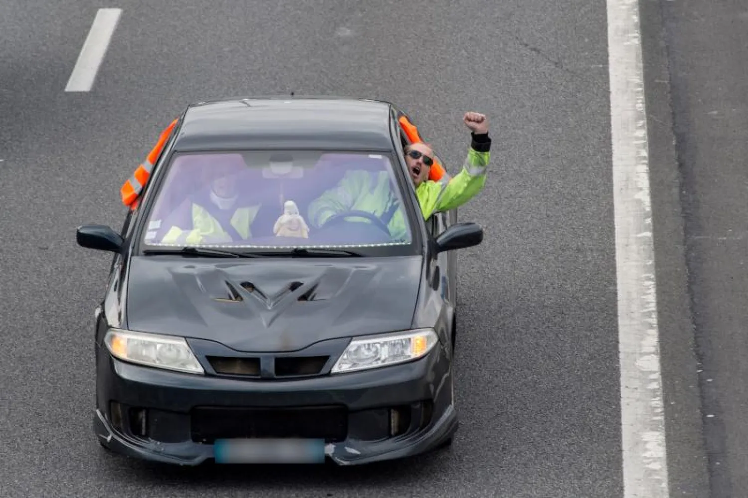 محتجّان في سيارة ساهمت في إبطاء السير على طريق في رين غربيّ فرنسا (أ. ف. ب)