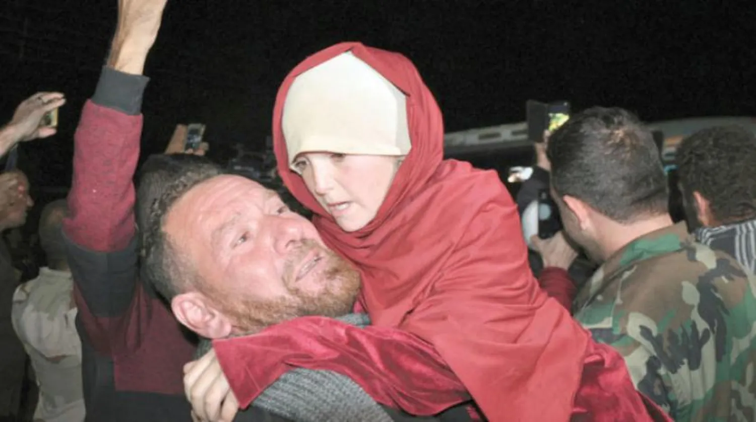 A man holds a young girl from Sweida rescued from ISIS. AP file photo