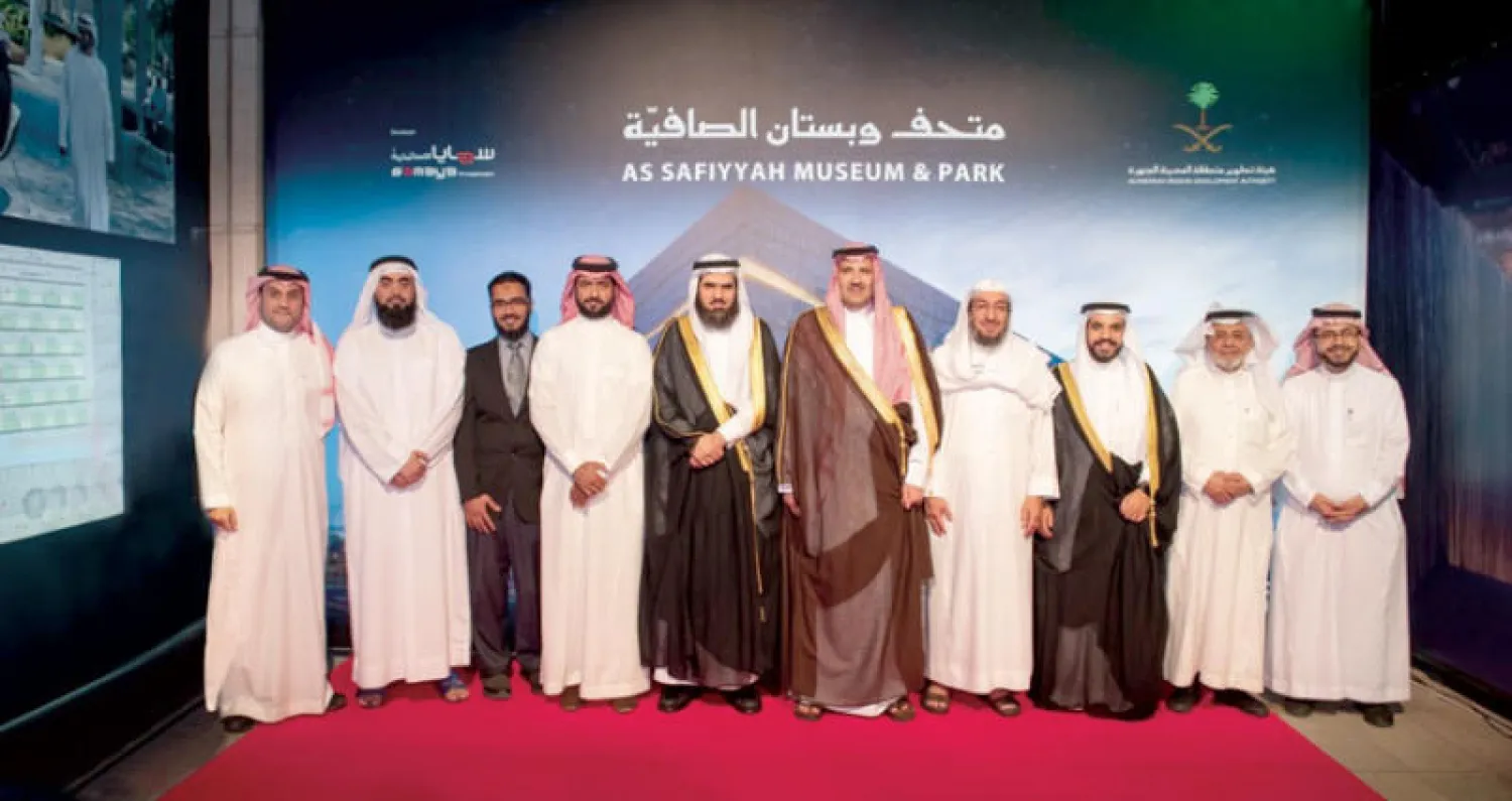 الأمير فيصل بن سلمان متوسطاً أعضاء المشروع النموذجي في تصاميم البناء («الشرق الأوسط»)