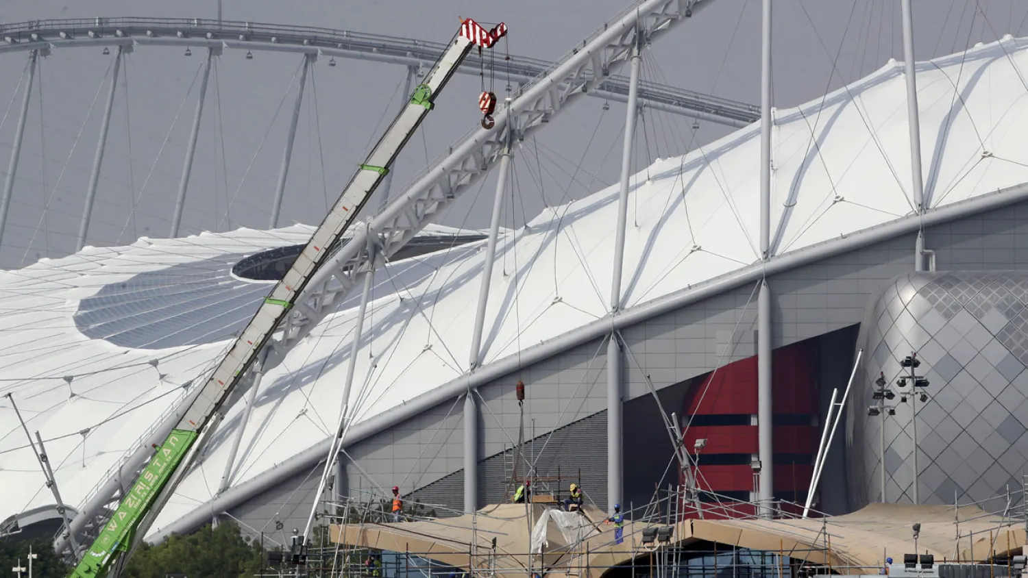 Workers are pictured on scaffolding at the Khalifa International Stadium on November 18, 2018, in Doha. (AFP)