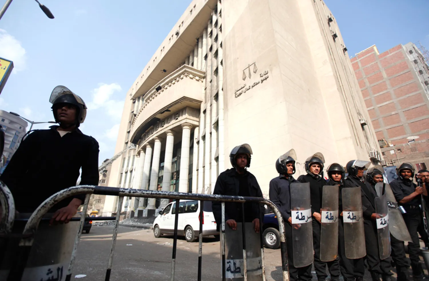 Policemen stand guard in front of a damaged building of a court complex after an explosion in Imbaba, north of Cairo January 14, 2014. (Reuters)