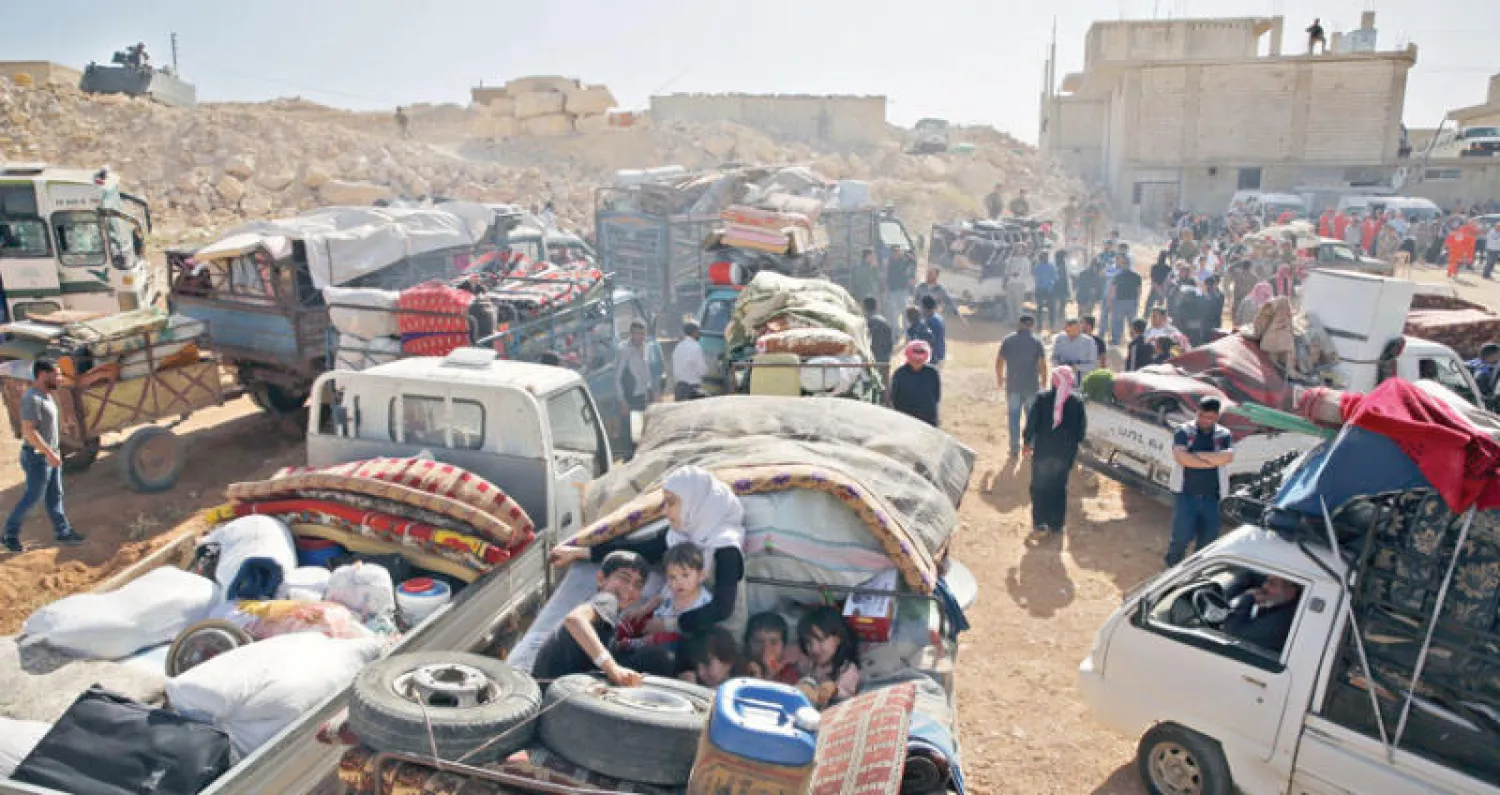 نازحون سوريون يغادرون عرسال في يونيو الماضي (إ.ب)