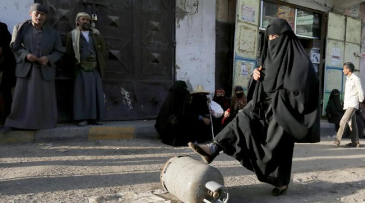 Yemenli bir kadın, Sana’da bir mutfak tüpünü iterken (IPA)