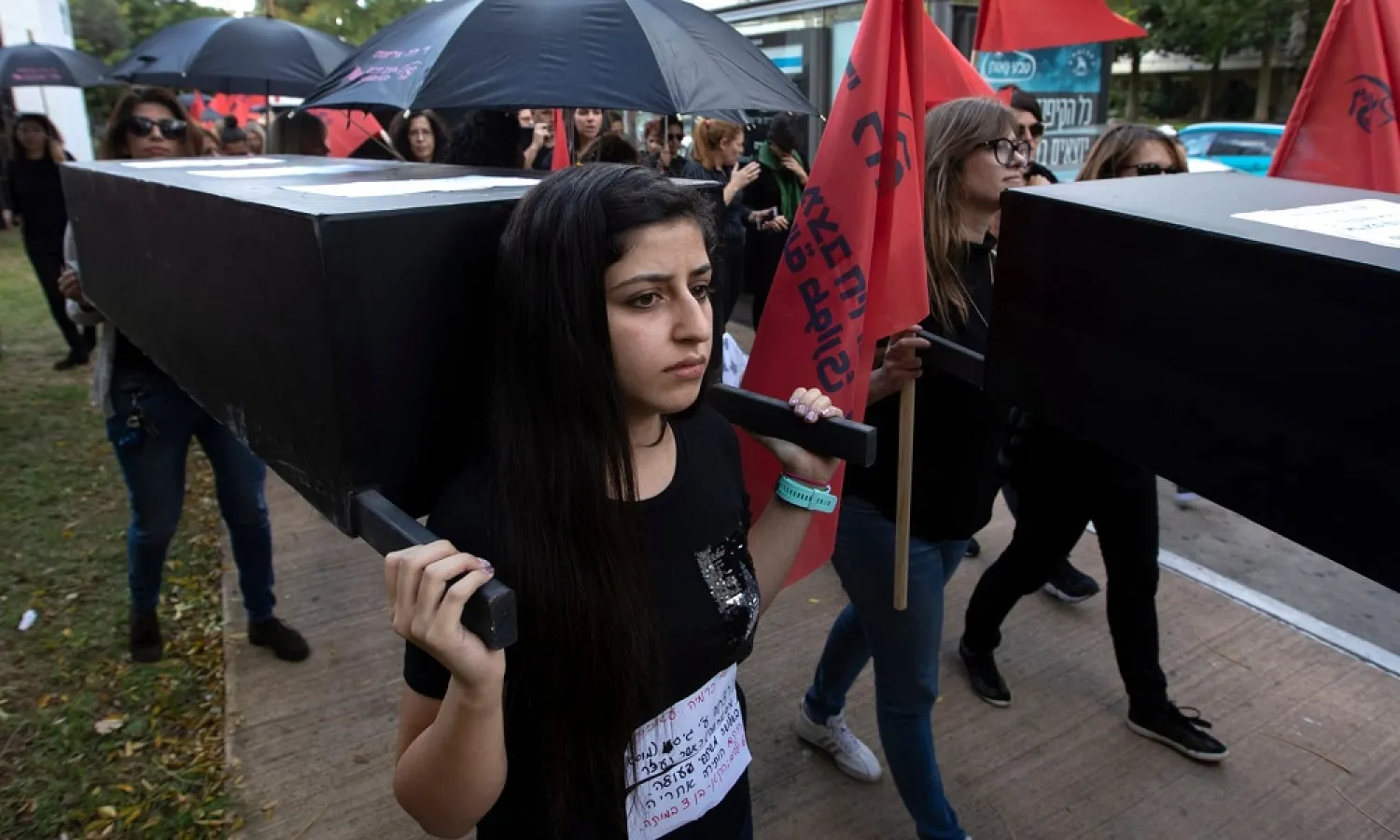A young Israeli woman carries a coffin during a protest held by family members and friends of women killed by violence in Tel Aviv, Israel. (EPA)