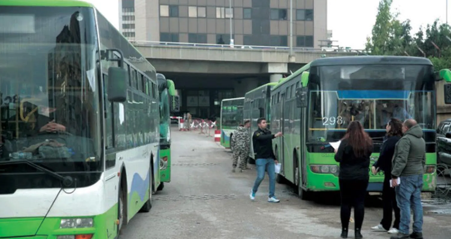 حافلات خضر تنتظر أن تقل لاجئين من لبنان إلى سوريا أمس (الوكالة الوطنية)