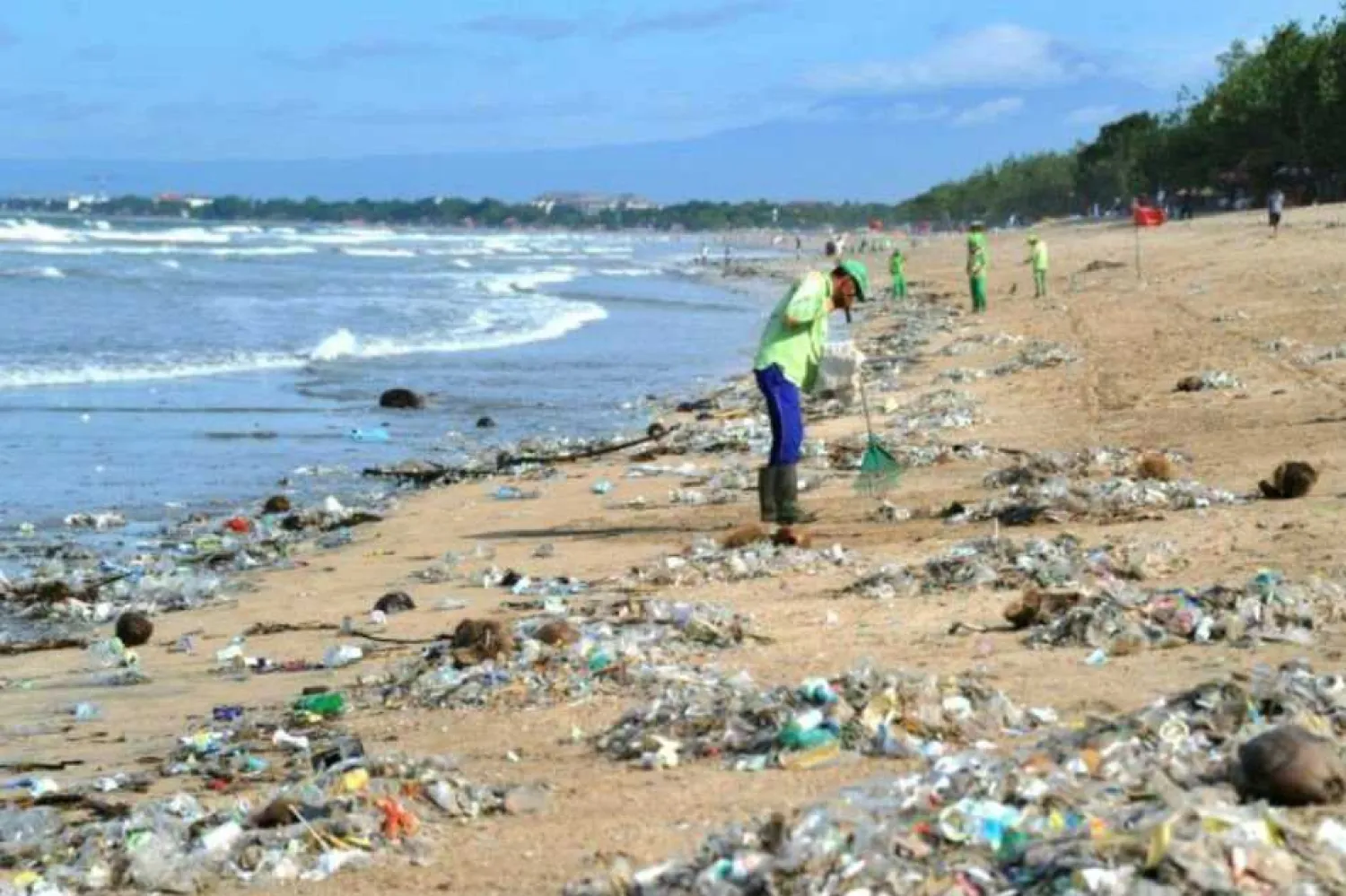 This photo taken on December 19, 2017 shows rubbish collectors clearing trash on Kuta beach near Denpasar, on Indonesia's tourist island of Bali. Sonny Tumbelaka, AFP