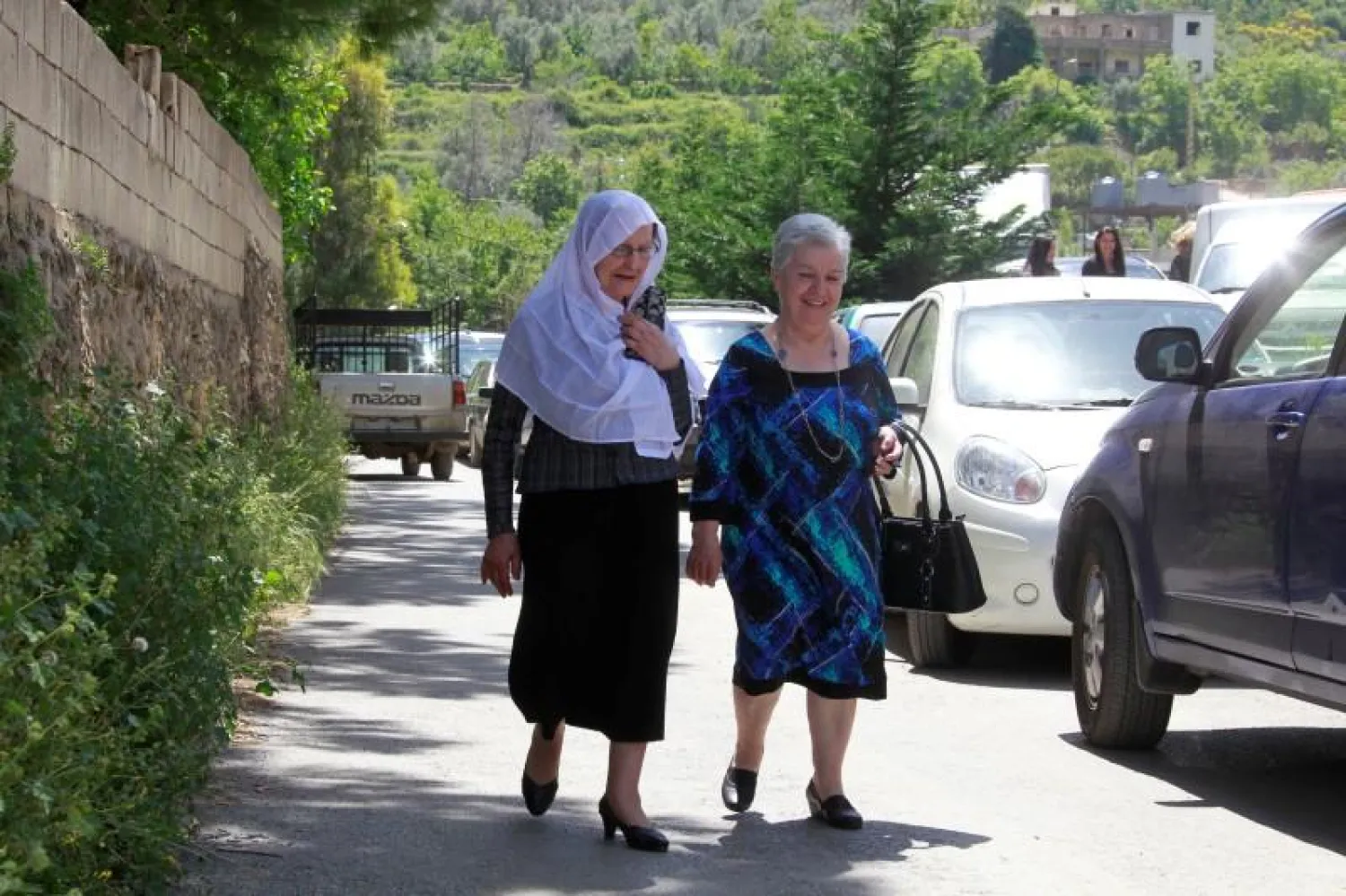 A Druze woman (L) walks with a Christian woman in the village of Brih, Lebanon April 23, 2016. REUTERS/Aziz Taher