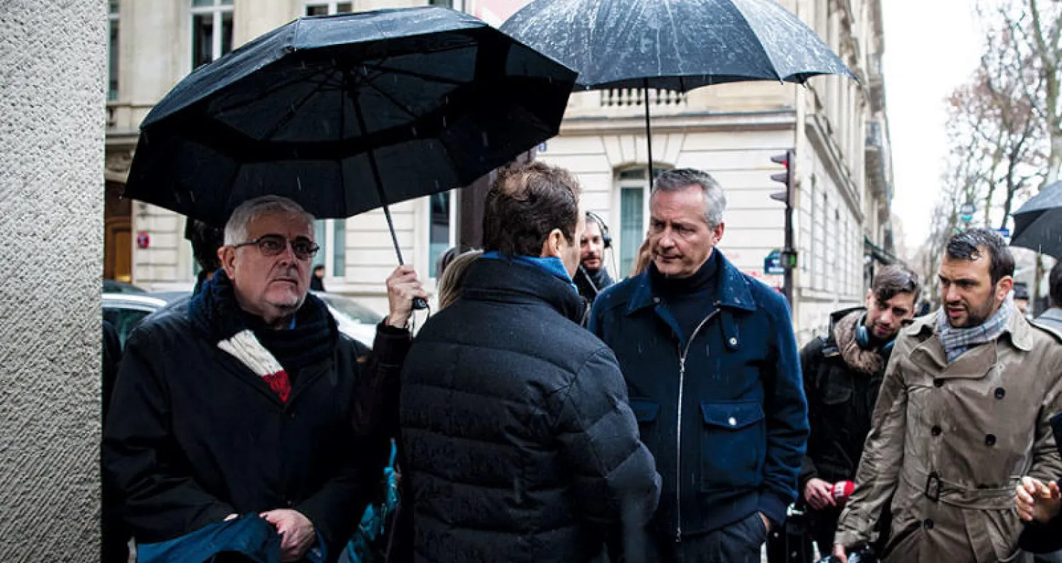 وزير المالية الفرنسي يتحدّث مع أصحاب متاجر تعرّضت للتخريب في باريس أمس (إ.ب.أ)