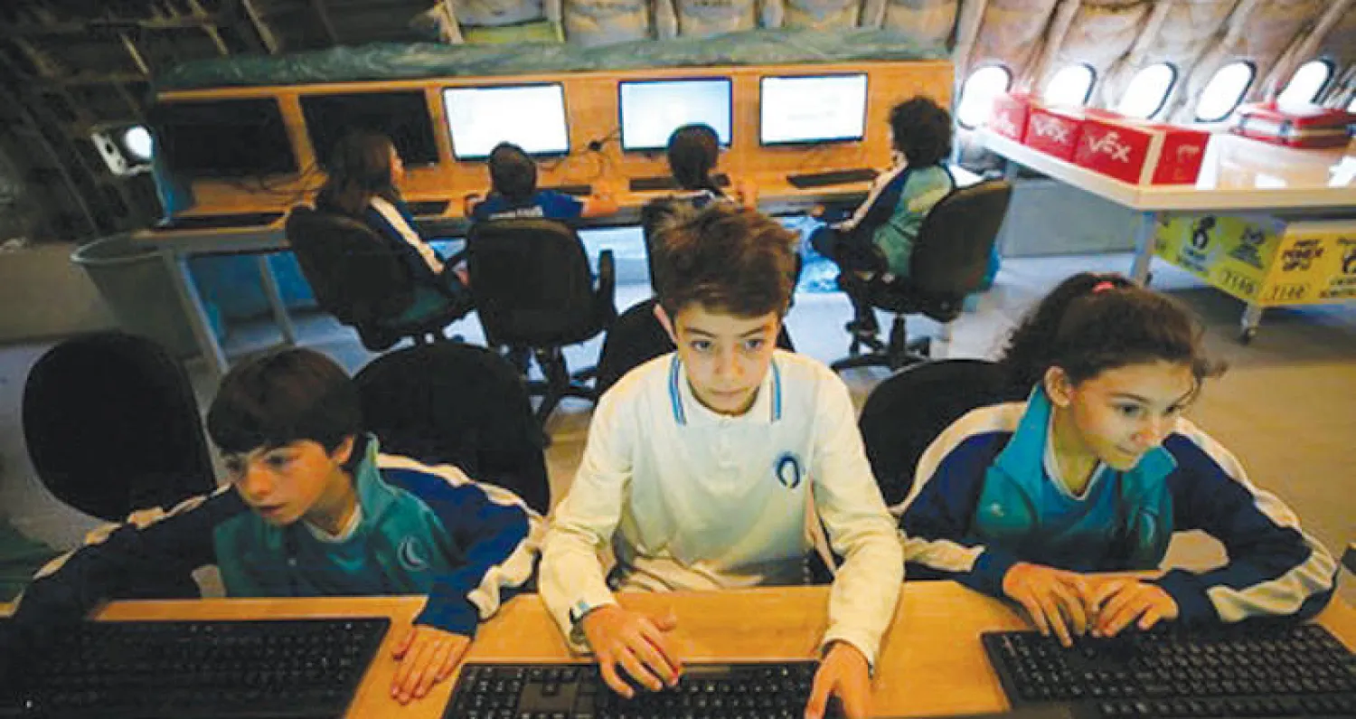 طلاب في حصة دروس الحاسوب بالطائرة في حديقة مدرسة بتركيا