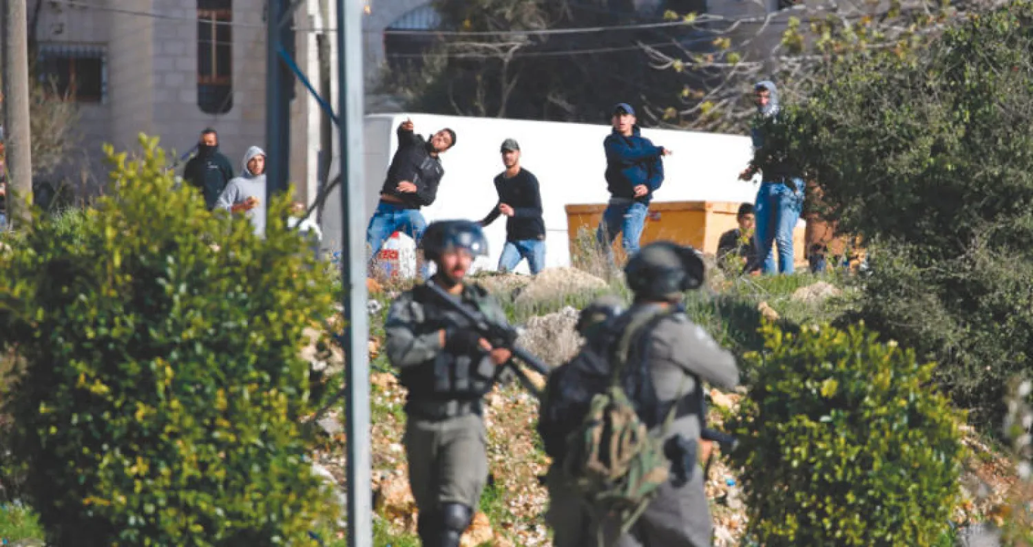 شبان يرشقون جنوداً إسرائيليين بالحجارة خلال المواجهات في رام الله أمس (أ.ف.ب)