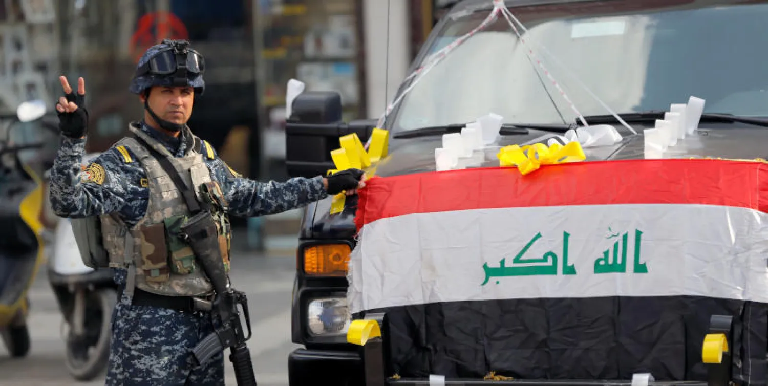 جندي عراقي يشير بعلامة النصر خلال الاحتفال بالذكرى السنوية الأولى للهزيمة العسكرية لتنظيم داعش (رويترز)