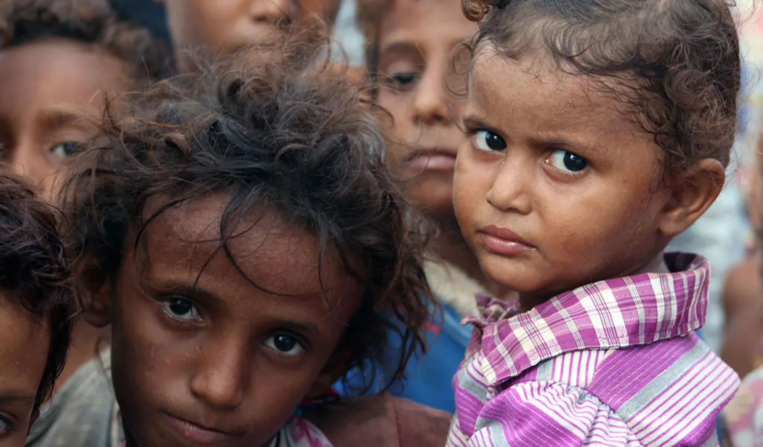 Displaced Yemeni children look on in a camp set up for people who fled the battle areas east of the port city of Hodeidah on September 15, 2018. (AFP)