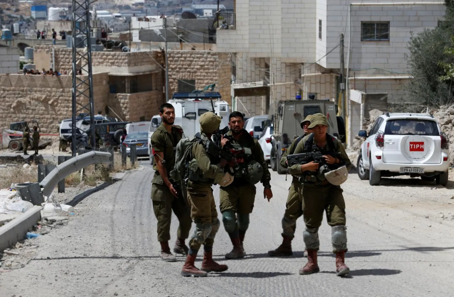 Israeli soldiers stand at the scene of attempted car ramming attack, in Hebron in the occupied West Bank June 2, 2018. REUTERS/Mussa Qawasma