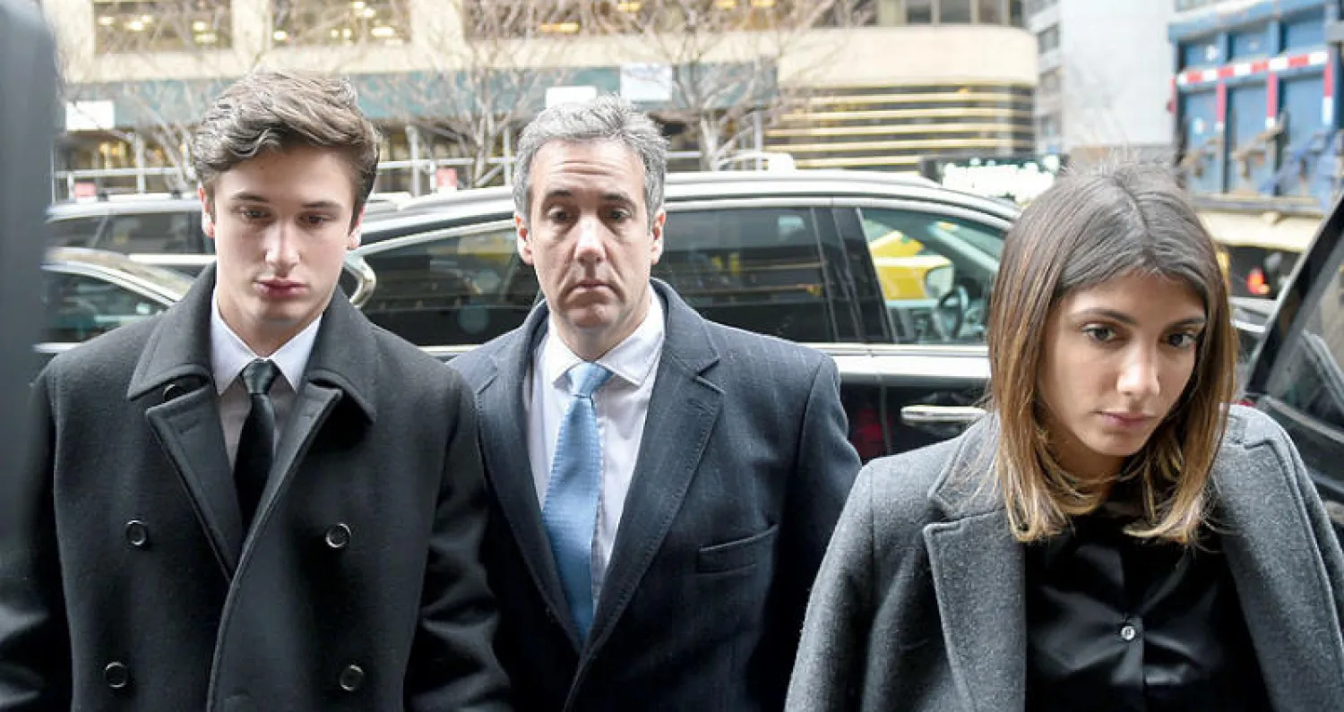 كوهن لدى عودته إلى منزله برفقة عائلته بعد الحكم عليه (رويترز)