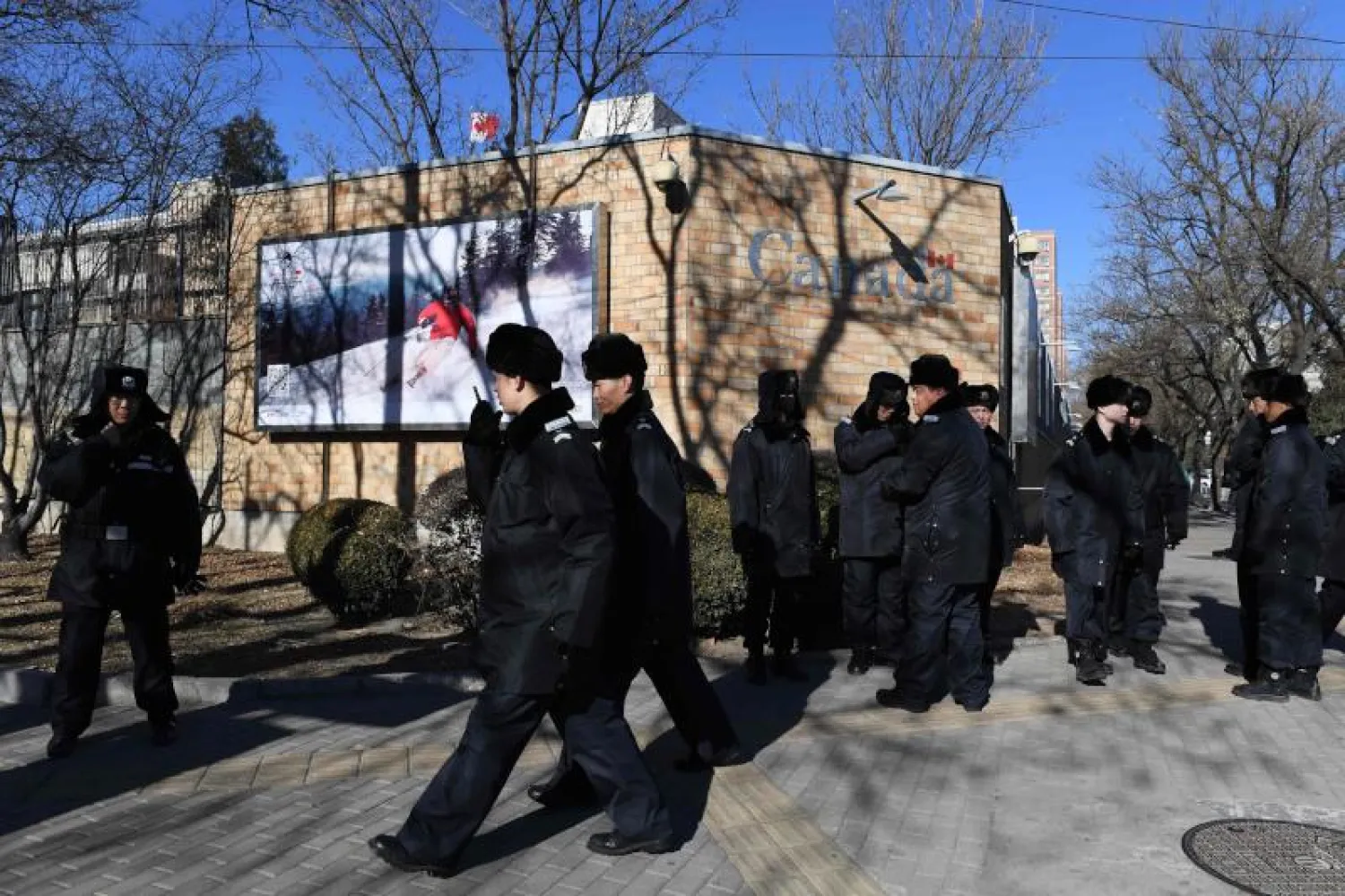 عناصر من الشرطة الصينية يقفون أمام السفارة الكندية في بكين (أ.ف.ب)