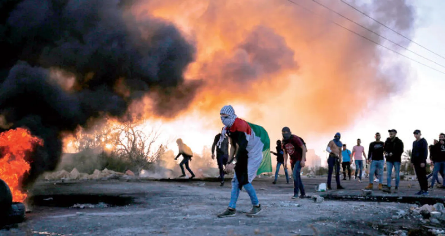 شبان فلسطينيون خلال المواجهات مع الجنود الإسرائيليين في رام الله (أ.ف.ب)