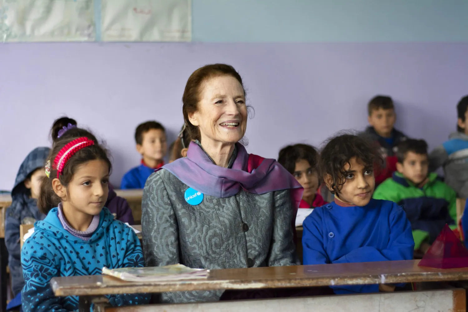 This Tuesday, Dec. 11, 2018 photo provided by UNICEF, shows UNICEF Executive Director Henrietta Fore, sitting with students during her visit to Alexandria school in Ma'ardes, Hama, Syria. (UNICEF via AP )