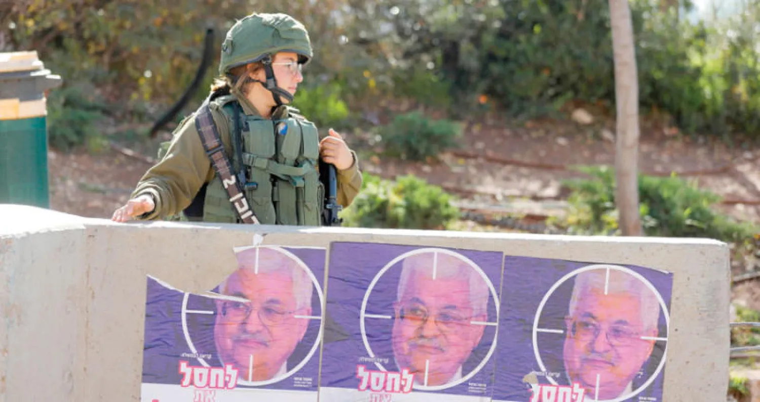 صور لعباس كتب عليها مستوطنون شعارات تحرض على قتله (أ.ف.ب)