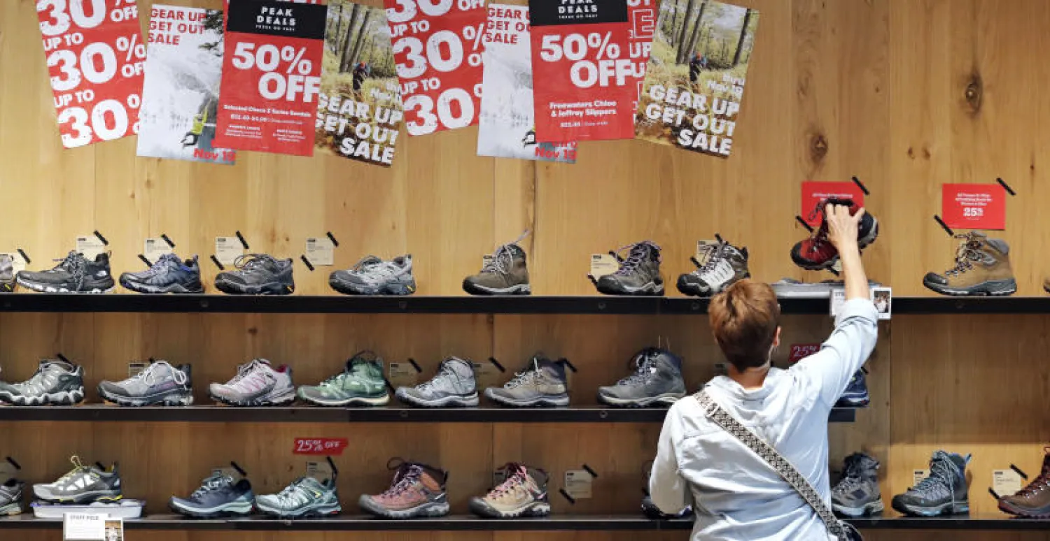 متسوق يفحص أحذية بأحد المتاجر في مدينة سياتل الأميركية (أ.ب)