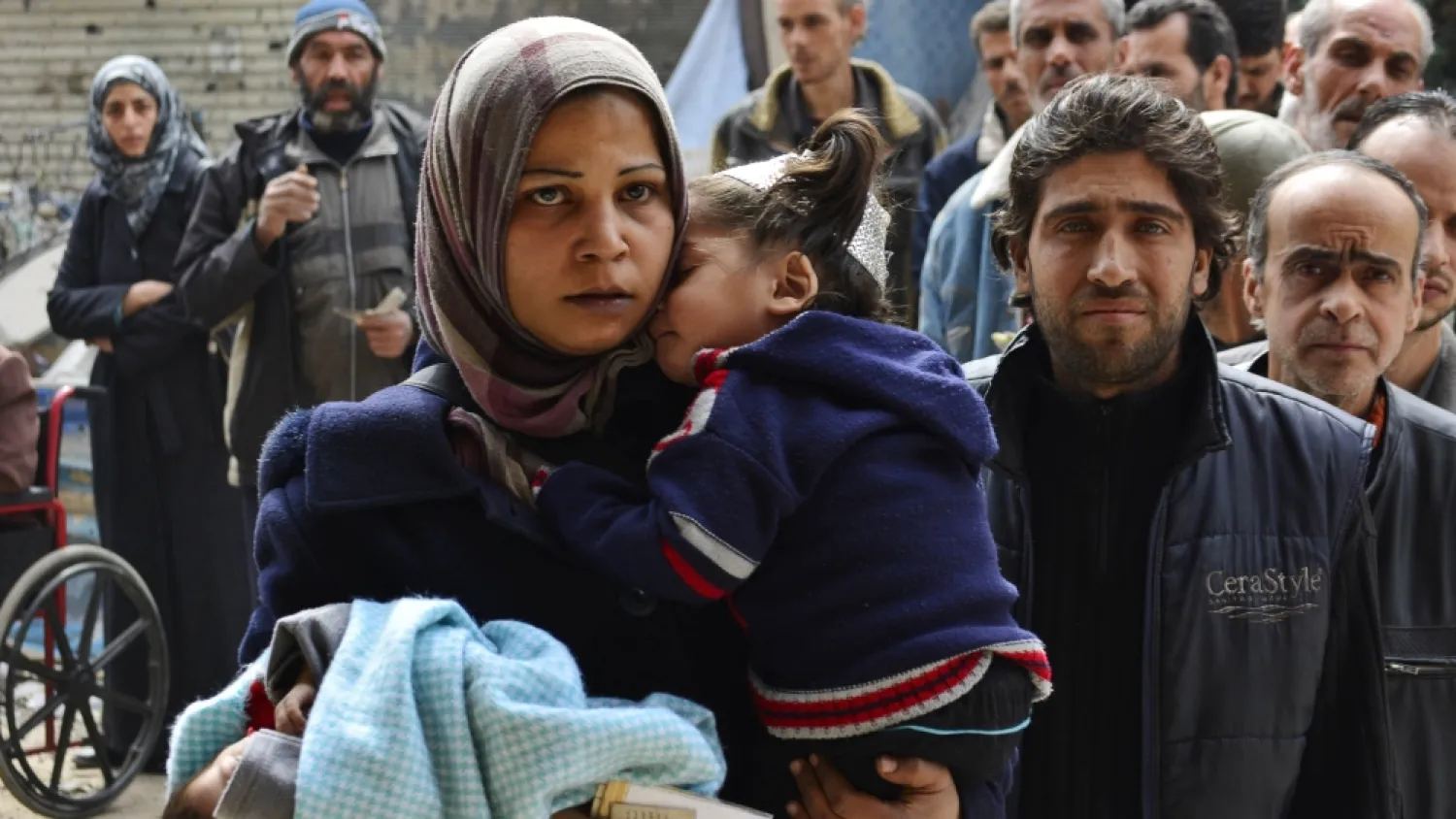 Residents queue up to receive humanitarian aid at the Palestinian refugee camp of Yarmuk. (Reuters)