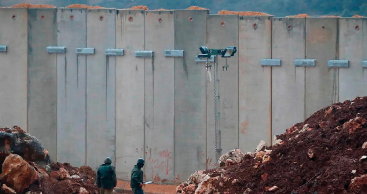 جنديان إسرائيليان قرب جدار اسمنتي ثبتته إسرائيل قرب حدودها مع لبنان (أ.ف.ب)