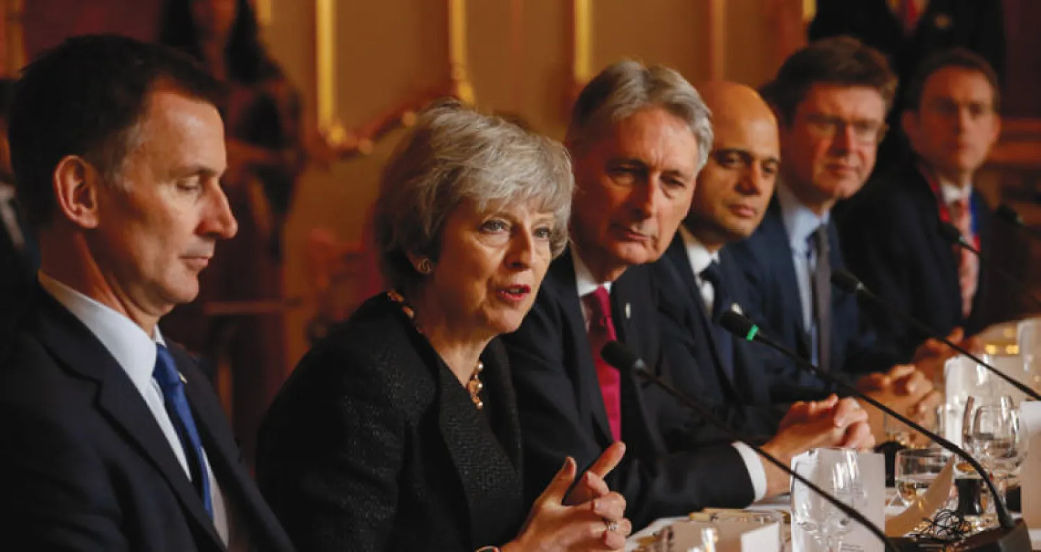 ماي تتوسط أعضاء حكومتها خلال اجتماع مع وفد بولندي بلندن أمس (إ.ب.أ)