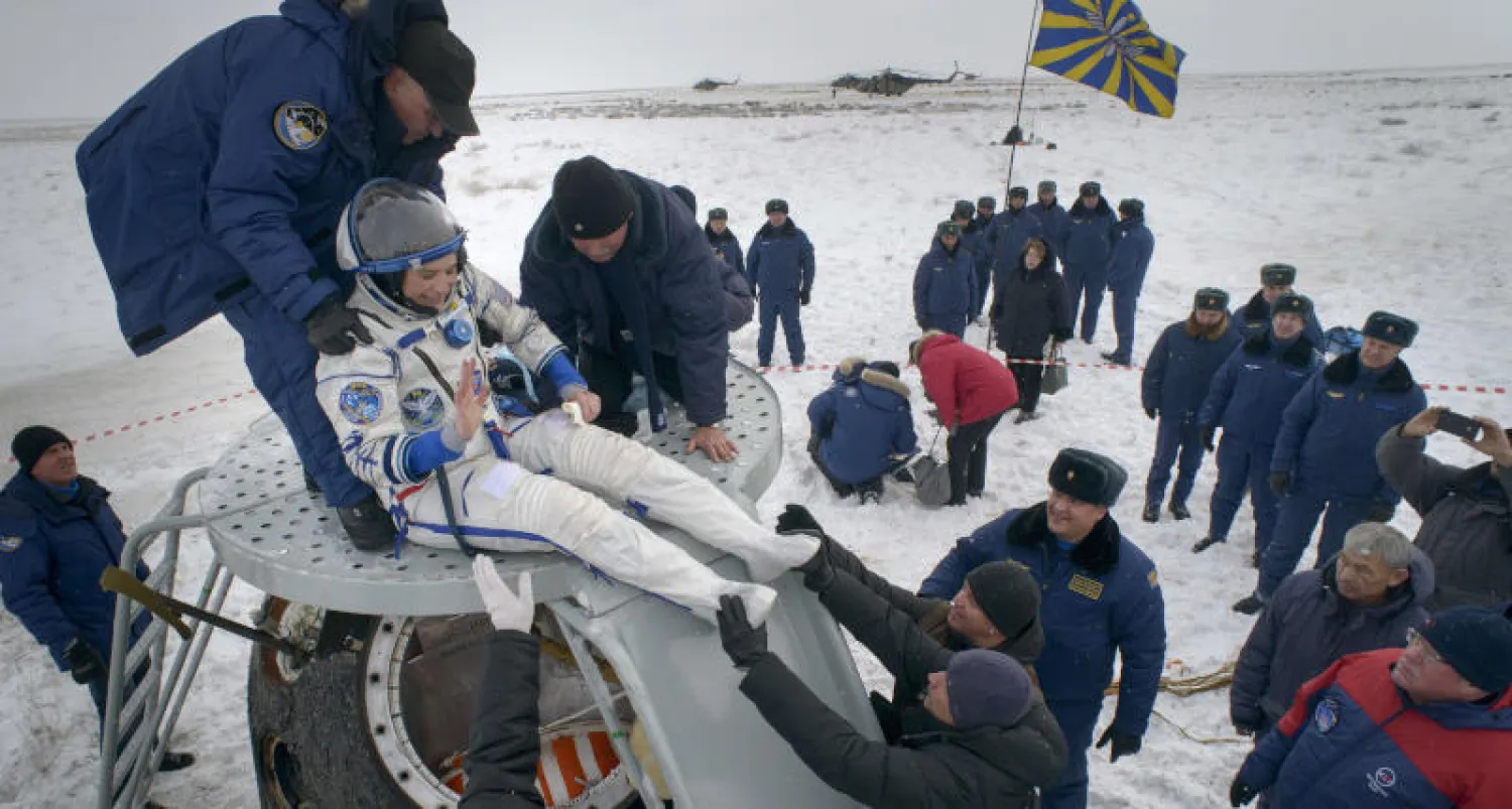 رواد الفضاء الثلاثة من ألمانيا وروسيا وأميركا عند عودتهم إلى الأرض (أ.ب)