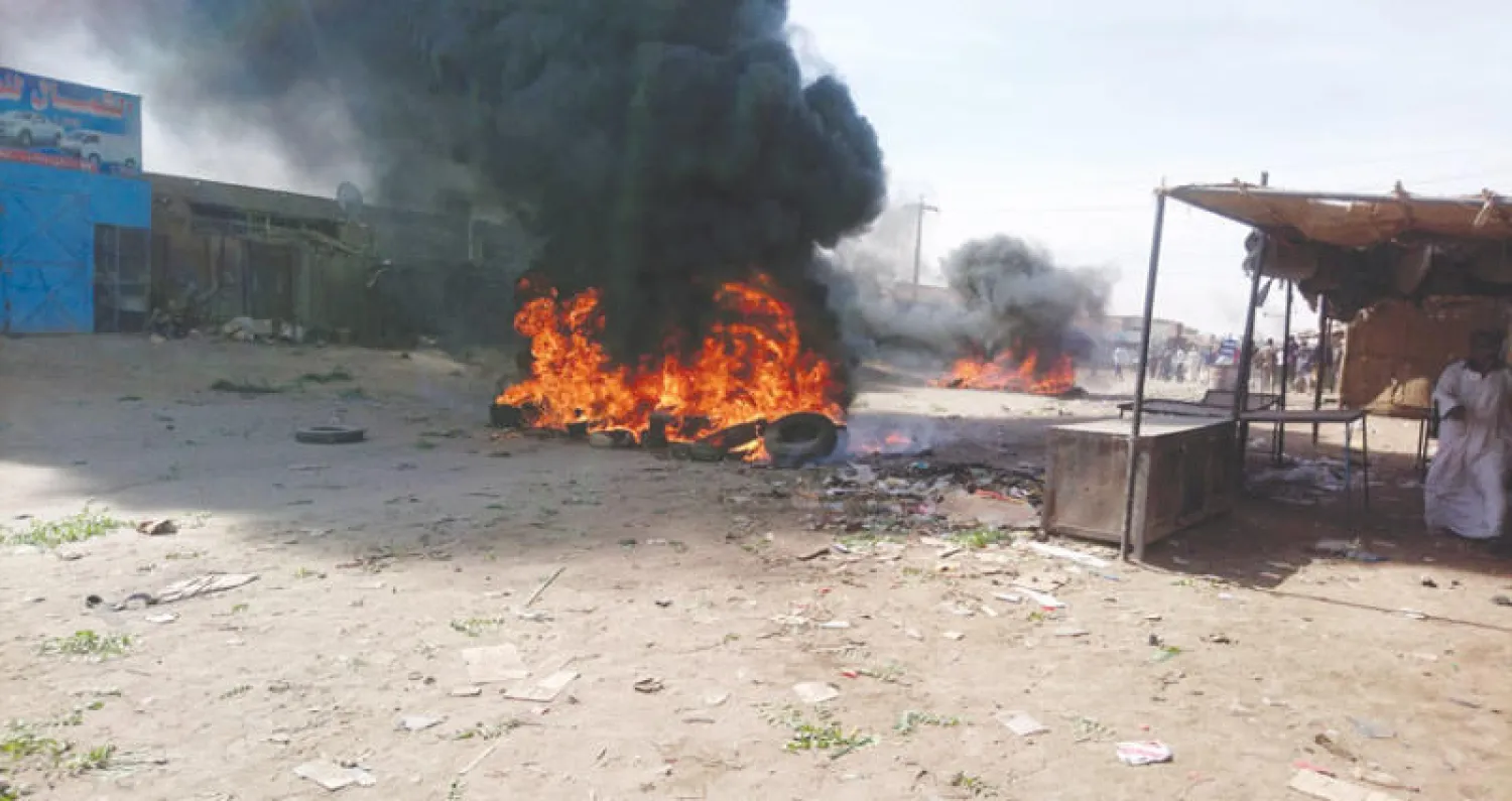 إطارات اشعلها المتظاهرون في أحد أحياء مدينة عطيرة بولاية نهر النيل (رويترز)